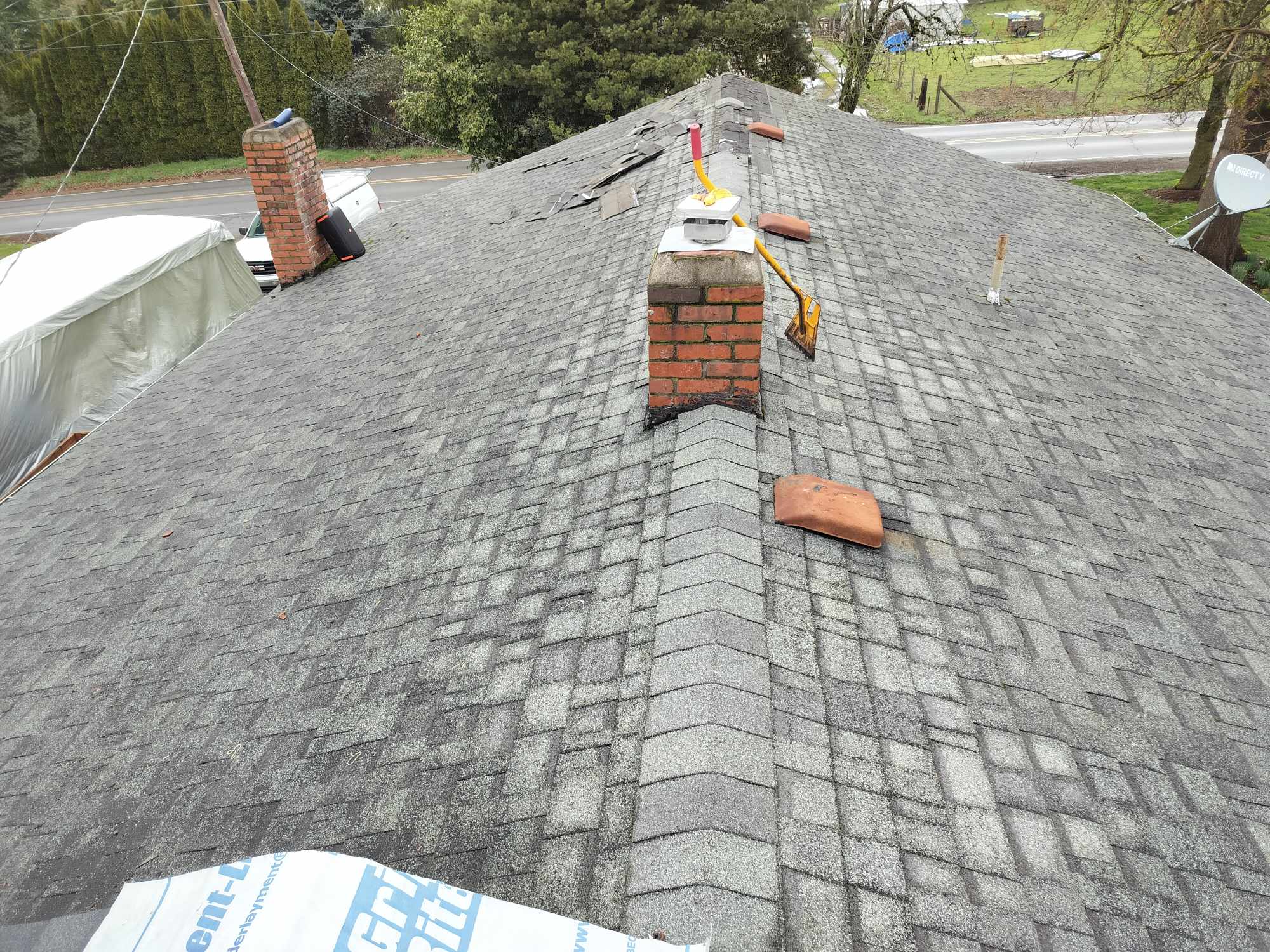 Chimney flashing and shingle work on an asphalt roof