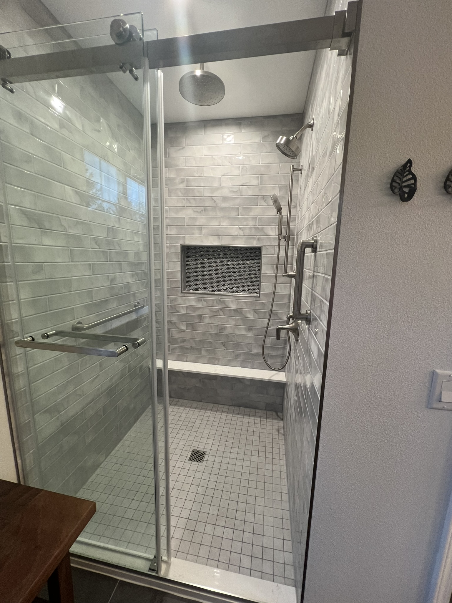 A finished tiled walk-in shower with a rain shower head