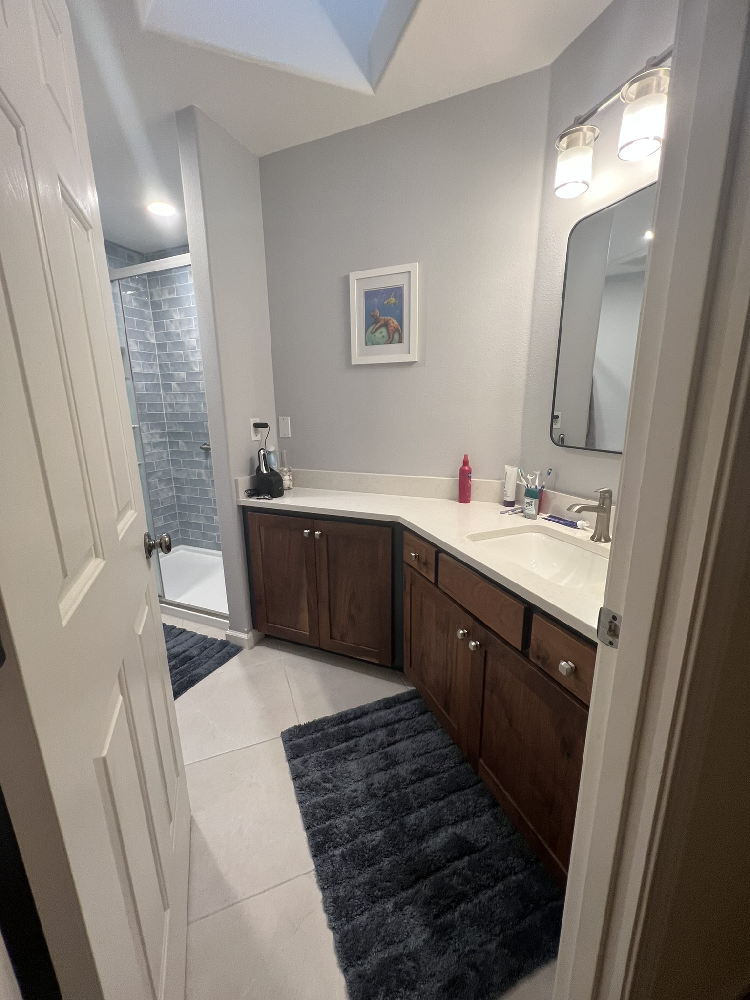 Finished bathroom vanity with tile shower beyond